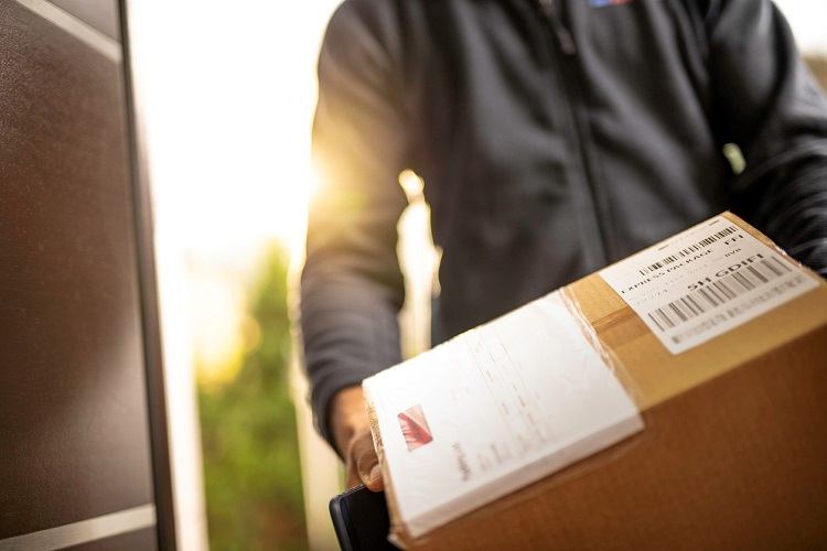 A delivery man holds a box