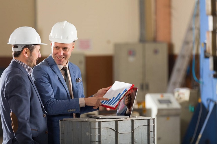 Two men in a warehouse discuss data